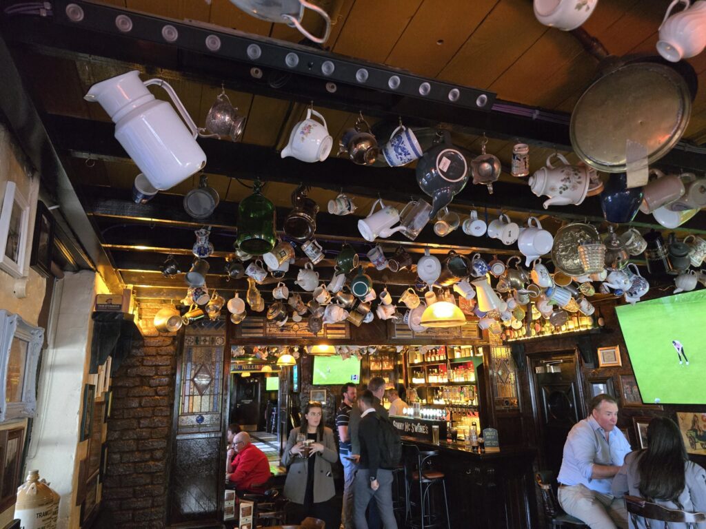A pub ceiling full of old jugs and teapots