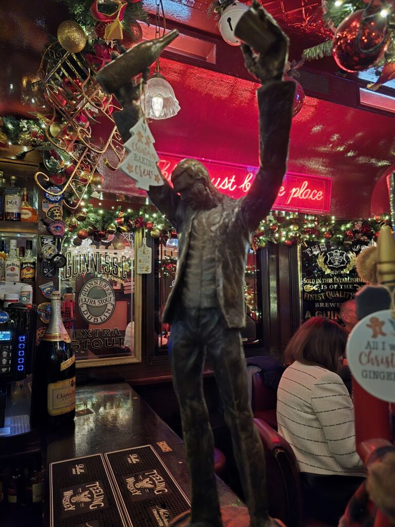 A bronze statue in a festively decorated pub